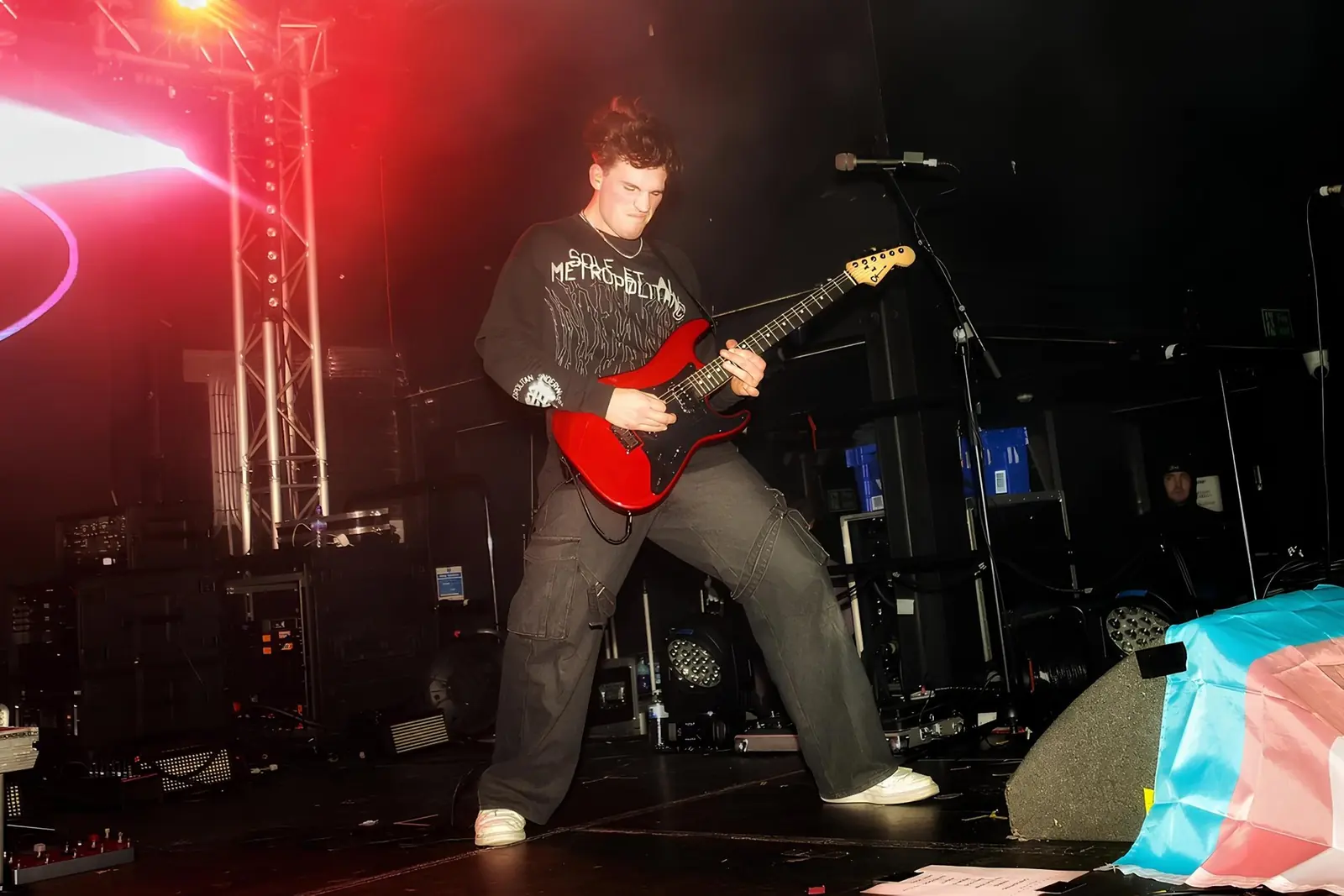 Aidan Mansell on stage with red guitar